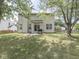 Large backyard featuring a patio, grill, green lawn, mature trees, and privacy fence at 1225 Berrywood Dr, Greenwood, IN 46143