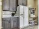 Well-equipped kitchen with grey cabinets, white fridge, and a practical storage rack at 1225 Berrywood Dr, Greenwood, IN 46143