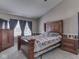 A well-lit main bedroom with a large bed, wood furniture, and a window at 1225 Berrywood Dr, Greenwood, IN 46143