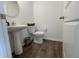 Well-lit half bathroom with pedestal sink, wood-look flooring and neutral paint at 1256 Little Rodeo Pl, Greenwood, IN 46143