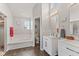 Bright bathroom featuring double sinks, tub and shower, and updated fixtures at 1260 Easton Point Dr, Greenwood, IN 46142