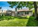 Spacious backyard with a deck, screened-in porch, and mature trees providing shade at 12922 St Andrews Way, Fishers, IN 46038