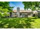Lush green backyard featuring a wooden deck, chimney, and screened-in porch at 12922 St Andrews Way, Fishers, IN 46038