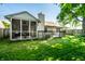 View of well-manicured backyard with screen porch, chimney and partial deck at 12922 St Andrews Way, Fishers, IN 46038