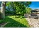 Lush green backyard with mature trees, a wooden fence, and a deck, perfect for outdoor enjoyment at 12922 St Andrews Way, Fishers, IN 46038