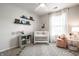 Cozy Bedroom featuring a white crib, decorative shelves, and a comfortable rocking chair at 12922 St Andrews Way, Fishers, IN 46038