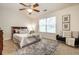 Comfortable bedroom with a ceiling fan, large window, and a cozy seating area at 12922 St Andrews Way, Fishers, IN 46038