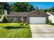 Charming single-story brick home featuring a well-manicured lawn, attached two-car garage and shuttered windows at 12922 St Andrews Way, Fishers, IN 46038