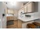 Bright kitchen featuring light wood cabinetry, white appliances, and a cozy breakfast bar area at 12922 St Andrews Way, Fishers, IN 46038