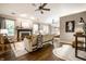 Cozy living room with wood floors, fireplace, and a ceiling fan at 12922 St Andrews Way, Fishers, IN 46038