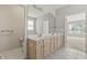 Bathroom featuring double sinks, a large mirror, and neutral tiling at 13172 Duval Dr, Fishers, IN 46037