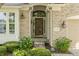 Close-up of a beautiful home entrance with decorative glass door, manicured bushes, and brick surround at 13172 Duval Dr, Fishers, IN 46037