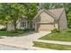 Beautiful brick home showcasing a well-kept lawn, lovely landscaping, large tree, and a two-car garage at 13172 Duval Dr, Fishers, IN 46037