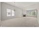 Sunlit living room featuring neutral carpet, a fireplace, large windows, and a chandelier at 13172 Duval Dr, Fishers, IN 46037