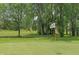 Well-manicured putting green on a golf course, surrounded by tall trees and blue sky at 13172 Duval Dr, Fishers, IN 46037
