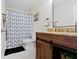 Modern bathroom featuring vanity with wood cabinets and a shower with geometric patterned curtain at 14754 Drayton Dr, Noblesville, IN 46062