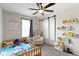 Cozy Bedroom with wood toddler bed, barn door closet, gray carpet, ceiling fan, and whimsical decor at 14754 Drayton Dr, Noblesville, IN 46062