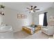 Bedroom with whimsical decor, gray carpet, toddler bed, ceiling fan, and changing table at 14754 Drayton Dr, Noblesville, IN 46062