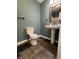 Well-lit bathroom with a pedestal sink, toilet, and decorative tiled floor at 1738 E 71St St, Indianapolis, IN 46220