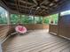 Covered deck showcasing a hanging chair swing with a view of the wooded backyard at 1738 E 71St St, Indianapolis, IN 46220