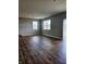 Spacious room with neutral walls, wood-look flooring, and sliding door to the backyard at 1932 Downey Ln, Greenfield, IN 46140