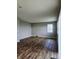 An empty living room with wood-look flooring, neutral walls, and a window at 1932 Downey Ln, Greenfield, IN 46140