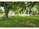 View of the back of the house from under a tree showing the generous backyard at 209 Howard Ave, Arcadia, IN 46030