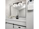 This bathroom boasts a modern vanity with sliding barn doors, a black faucet, and an oversized mirror at 209 Howard Ave, Arcadia, IN 46030
