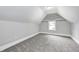 This bedroom boasts an attic ceiling, neutral carpet and paint, and a window at 209 Howard Ave, Arcadia, IN 46030