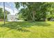 Spacious yard showcasing the house and a back deck, bordered by mature trees at 209 Howard Ave, Arcadia, IN 46030