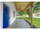 Inviting covered front porch featuring a bright blue door and exposed wood rafters at 209 Howard Ave, Arcadia, IN 46030