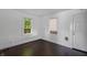 Bright bedroom with hardwood floors, two windows, and fresh white walls at 2400 Walnut St, Anderson, IN 46016