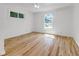 Light-filled bedroom with hardwood floors, white walls, ceiling fan and two windows at 2400 Walnut St, Anderson, IN 46016