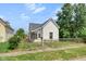 Charming home with white siding, a gray roof, and a small front yard with chainlink fence at 2400 Walnut St, Anderson, IN 46016