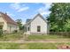 Charming home with white siding, a gray roof, and a small front yard with chainlink fence at 2400 Walnut St, Anderson, IN 46016