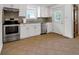 Kitchen with white cabinets, stainless steel appliances, tile floors, and a door to the outside at 2400 Walnut St, Anderson, IN 46016
