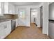 Bright kitchen featuring stainless steel appliances, white cabinets, and mosaic tile backsplash at 2400 Walnut St, Anderson, IN 46016