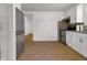 Bright kitchen featuring white cabinetry, stainless steel appliances, and tan tile flooring at 2400 Walnut St, Anderson, IN 46016