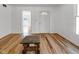 Bright living room with hardwood floors, white walls, and a white door at 2400 Walnut St, Anderson, IN 46016