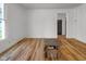 Bright living room with hardwood floors, white walls, and a doorway leading to another room at 2400 Walnut St, Anderson, IN 46016