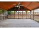 Spacious screened porch with wooden flooring, ceiling fan, and a cozy outdoor living space at 2400 Walnut St, Anderson, IN 46016