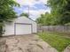 View of garage, backyard, and patio featuring green grass and a wooden fence at 3936 Graceland Ave, Indianapolis, IN 46208