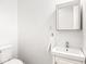 Cozy half bathroom with a square mirror, bright vanity, and commode at 3936 Graceland Ave, Indianapolis, IN 46208