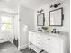 Bright bathroom with a marble countertop vanity, dual sinks, and modern light fixtures at 3936 Graceland Ave, Indianapolis, IN 46208