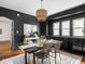 Dining room with black walls, stylish rug, woven light fixture, and seating for six at 3936 Graceland Ave, Indianapolis, IN 46208