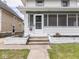 Home exterior showcasing a landscaped yard, a porch and white walls and pillars at 3936 Graceland Ave, Indianapolis, IN 46208