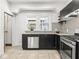 Modern kitchen features stainless steel appliances, dark cabinetry, granite countertops, and mosaic tile backsplash at 3936 Graceland Ave, Indianapolis, IN 46208