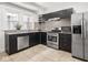 Modern kitchen featuring stainless steel appliances, granite countertops, and sleek black cabinets at 3936 Graceland Ave, Indianapolis, IN 46208