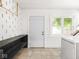 Spacious laundry room with laundry machine, built-in shelving, and an exterior door at 3936 Graceland Ave, Indianapolis, IN 46208