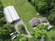 Expansive property featuring a metal building, house, outbuildings, driveway, and green spaces at 3942 Senour Rd, Indianapolis, IN 46239